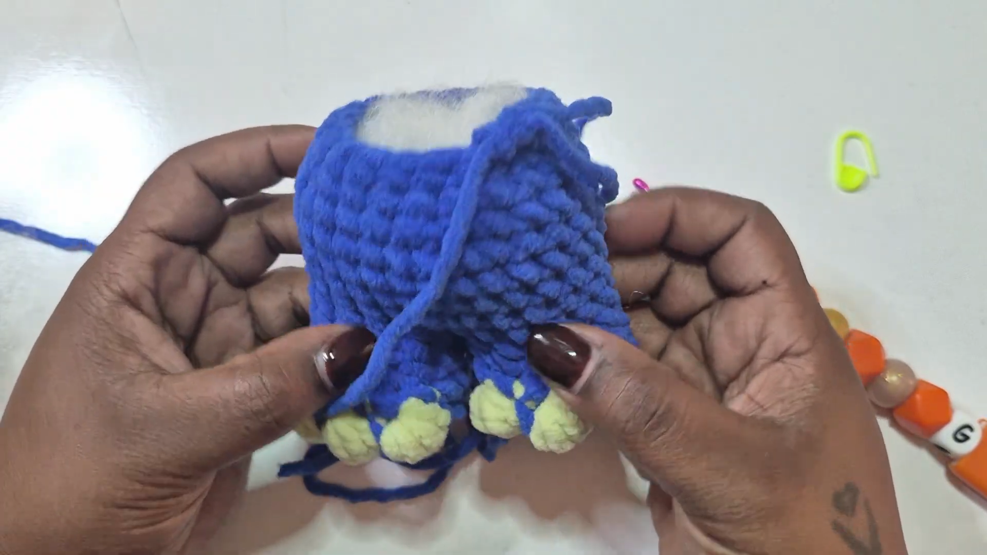 Blue crochet piece showing pale green toe tips