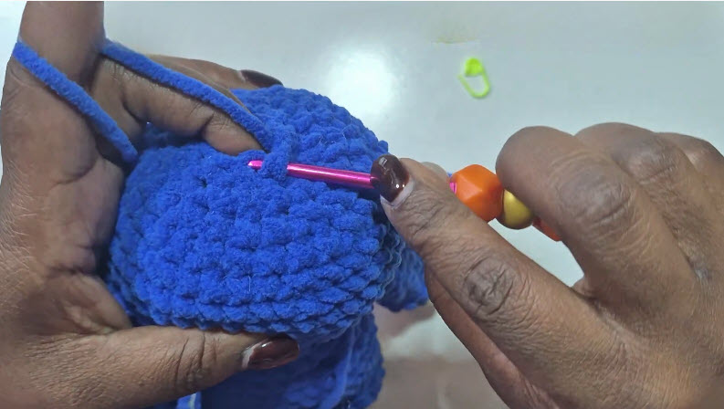Closing the final decrease round on blue crochet head