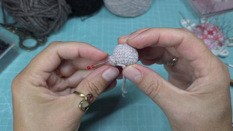 Crocheted head with pin marking eye spot