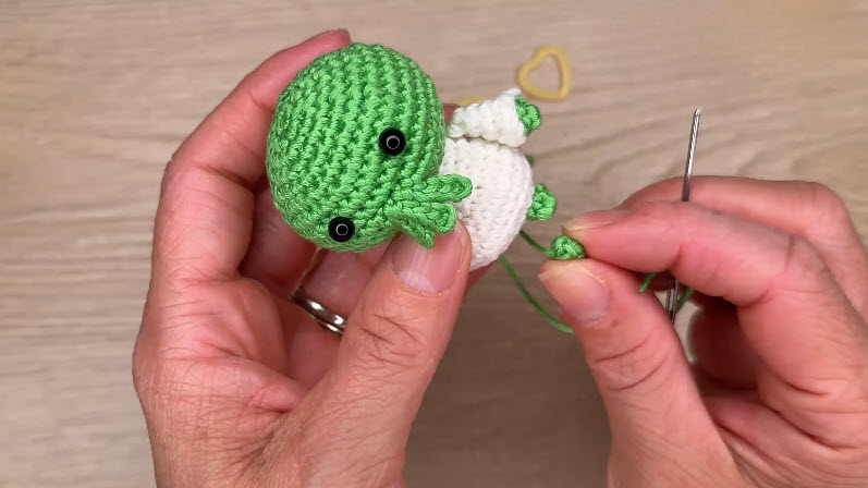 Green and white amigurumi parts assembled together