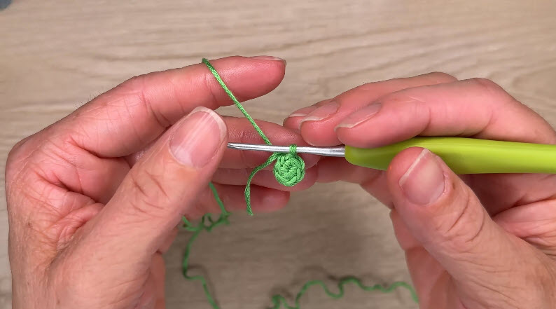 Green magic ring being crocheted on hook