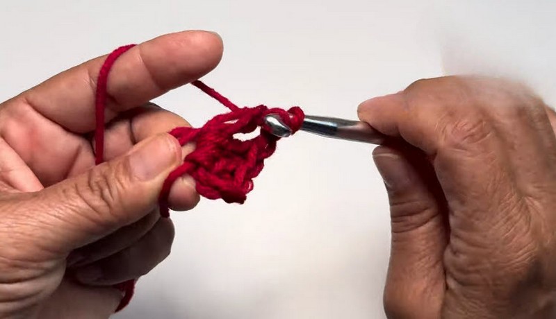 Starting the red granny square with the first stitches.