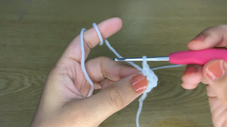 Crochet frog slipper eye started with white yarn on a pink hook